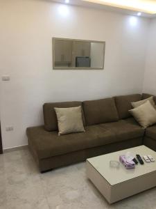 a living room with a brown couch and a mirror at New and cosy apartment in Amman (Al Weibdeh) in Amman