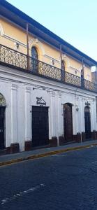 un edificio blanco con puertas negras en una calle en Misti Hostel B&B en Arequipa