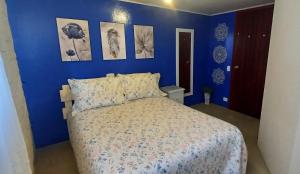a blue bedroom with a bed and pictures on the wall at Recanto do Sonho em Campos do Jordão in Campos do Jordão