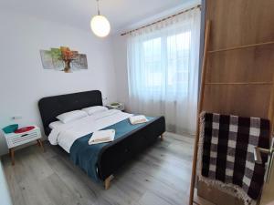 um quarto com uma cama grande e uma janela em Quiet and Cozy 2 bedroom flat with free parking included em Floresti