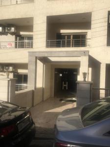 安曼的住宿－New and cosy apartment in Amman (Al Weibdeh)，停车场,停车场的汽车停在大楼前