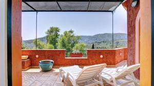 a patio with white chairs and a large window at Kornata Country House in Kornáta