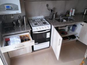 una pequeña cocina con fogones y fregadero en El Descanso en Salta