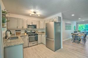 a kitchen with a refrigerator and a table with chairs at Lakefront Townville Gem with Boat Dock and Kayaks in Townville