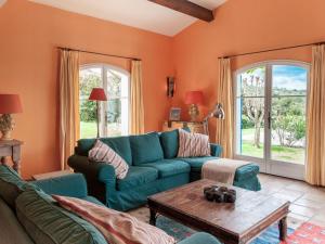uma sala de estar com um sofá azul e uma mesa em Beautiful villa near Valbonne with garden em Villeneuve-Loubet