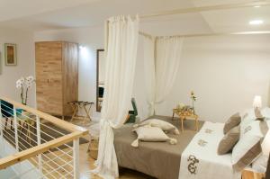 een slaapkamer met een groot bed met witte gordijnen bij Loft del Teatro in Siracusa
