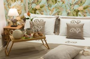 een bed met een tafel met een dienblad met eten erop bij Loft del Teatro in Siracusa