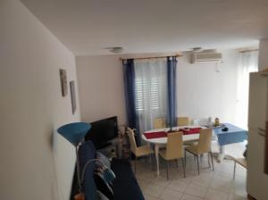 - une cuisine et une salle à manger avec une table et des chaises dans l'établissement Apartment Karlo, à Supetar