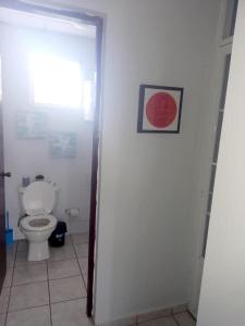 a bathroom with a toilet and a picture on the wall at Vista Azul in Aguada