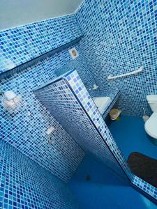 a blue tiled bathroom with a toilet and a sink at Departamento frente a la playa in Playas +34 photos