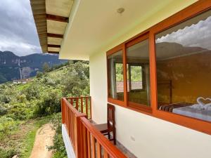 a house with a balcony with a view of the mountains at La Rivera de Gocta in Cocachimba