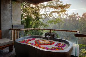 a bathtub made out of flowers in a garden at Kastara Resort in Ubud