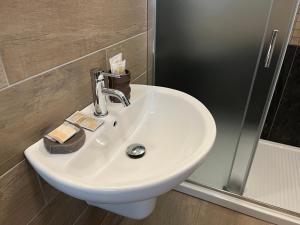 lavabo blanco en el baño junto a una ducha en Agriturismo La Costa dei Trabocchi, en Torino di Sangro