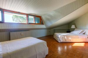 Un dormitorio abuhardillado con dos camas y una ventana. en Villa Rosaria by Mmega, en Ripe 37 fotos más