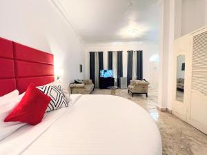 a bedroom with a large white bed with a red headboard at Jamaica Palace Hotel in Port Antonio