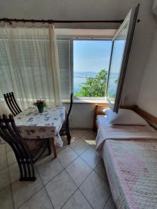 ein Schlafzimmer mit einem Tisch und einem Bett und einem Fenster in der Unterkunft Apartments - Buffet 2B in Sveti Juraj