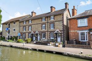 a large brick building next to a river at 4 Canalside Cottages in Towcester