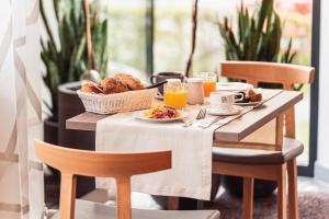 a table with a breakfast of bread and orange juice at Hotel Birkenhof in Bad Radkersburg