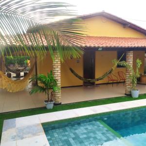 a house with a swimming pool in front of it at Borogodó House in Barra Grande