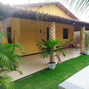 a house with a palm tree in front of it at Borogodó House in Barra Grande