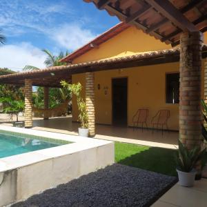 a house with a swimming pool and a patio at Borogodó House in Barra Grande