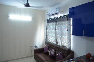 a living room with a couch and a window at Oviyam Sea view Apartment, feel like home in Chennai