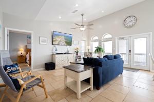 een woonkamer met een blauwe bank en een tafel bij Marisol - PET FRIENDLY and Gulf Front! Enjoy the large deck with amazing views! home in Dauphin Island