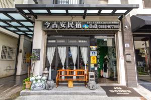 un frente de tienda con un banco delante de él en 今古安民宿 - 步行東大門夜市3分鐘, en Hualien City