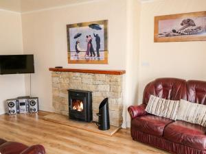 a living room with a couch and a fireplace at Bridgetown Cottage in Kerrykeel