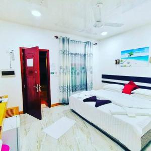 Un dormitorio con una cama grande con una puerta roja. en Summer Sky Thoddoo, en Thoddoo