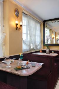 Un comedor con una mesa y un espejo. en Contact Hôtel de France Contres-Beauval-Cheverny, en Contres