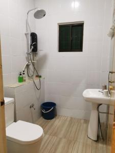 bagno con servizi igienici, lavandino e finestra di ANG LEE HOLIDAY HOME 1 a Semporna