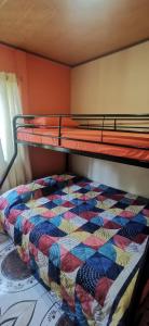 a bottom bunk bed with a colorful quilt on it at Starfish Cahuita's House - Casa Vacacional in Cahuita