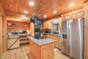 a kitchen with wooden cabinets and a stainless steel refrigerator at Relaxing Cabin near Bear Claw Vineyard, Hot Tub, Game Room, Pet Friendly, sleeps10 in Blue Ridge +25 photos