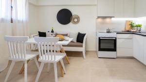 cocina y comedor con mesa y sillas en Olea Suites en Gouves