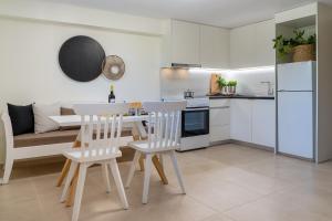 a kitchen and living room with a table and chairs at Olea Suites in Gouves