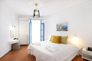 a bedroom with a large white bed and a mirror at Kirki Village-Adults Only in Panormos Rethymno