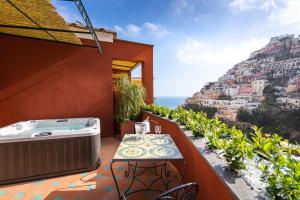 a balcony with a hot tub and a table at Hotel Savoia in Positano