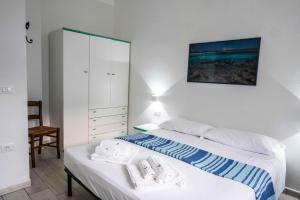 a bedroom with a bed with towels on it at Biriola EcoResort Cala Gonone in Cala Gonone