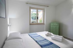 a bedroom with a bed with towels and a window at Biriola EcoResort Cala Gonone in Cala Gonone