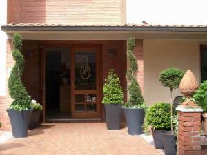 un bâtiment avec des plantes en pot devant une porte dans l'établissement Hotel Mirella, à Castiglione della Pescaia