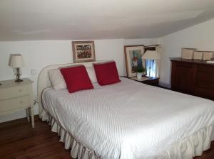 a bedroom with a white bed with two red pillows at Casa Rural Saint Joseph in Peralejo +36 photos