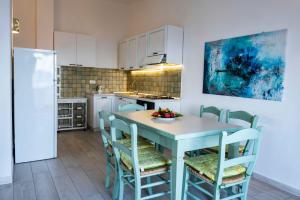 a kitchen with a table and chairs with a bowl of fruit on it at Biriola EcoResort Cala Gonone in Cala Gonone
