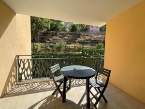 d'une table et de chaises sur un balcon avec vue. dans l'établissement Bel Appartement au calme avec parking, à Menton