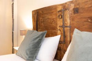 uma cama com duas almofadas e uma cabeceira em madeira em Corte del Cedro em Provaglio d'Iseo