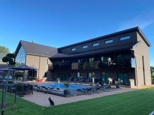 un grand bâtiment avec une piscine devant dans l'établissement SKY Villa, à Palanga