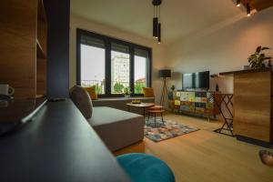 a living room with a couch and a tv at STUDIO K district (central BG+private parking) in Belgrade