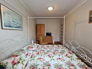 1 Schlafzimmer mit einem Bett mit Blumenbettdecke in der Unterkunft Pokoje Gościnne Orla 4 i in Misdroy