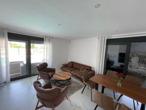 a living room with a couch and a table and chairs at Vila Softic Amra in Umag