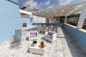 een patio met stoelen en een tafel op een dak bij Stella Maris Case Vacanze in Balestrate